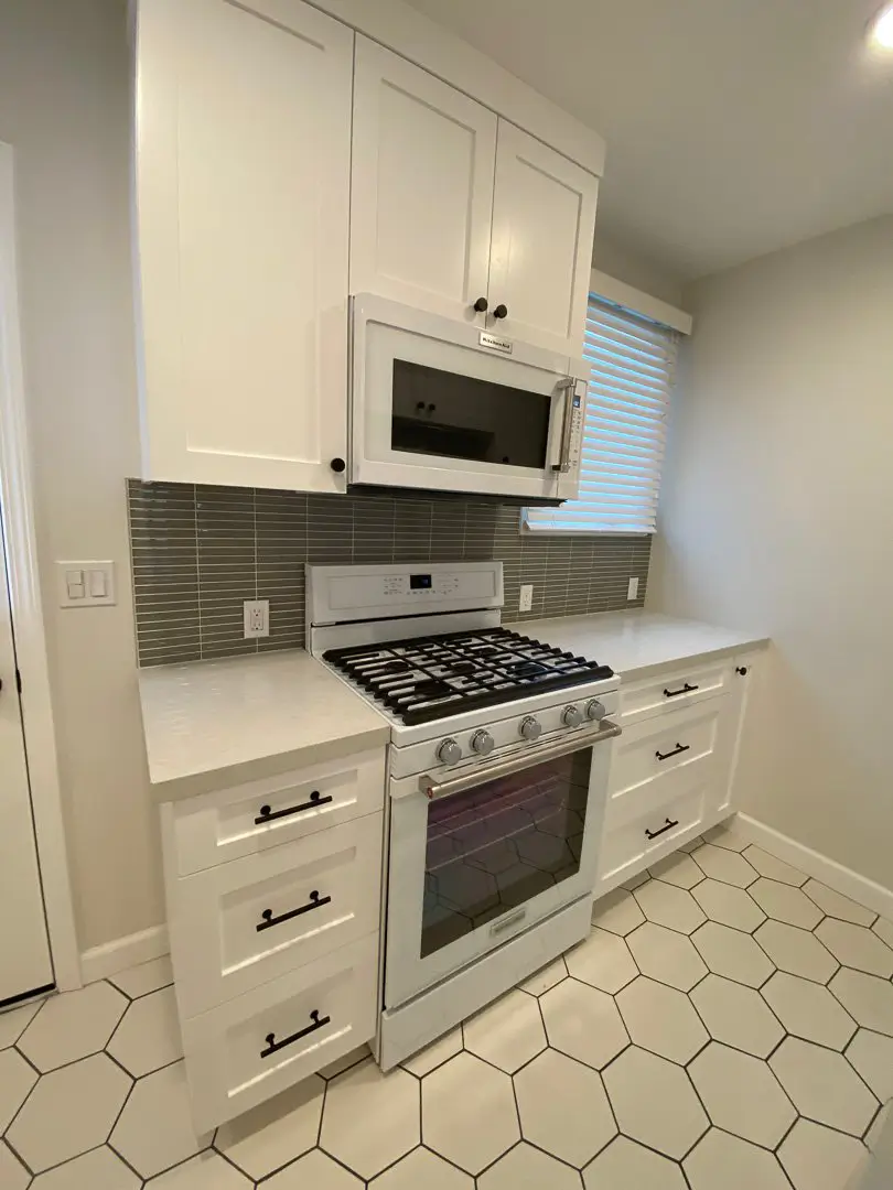 Cabrillo Bungalows kitchen with gas range, glass tile backsplash and white shaker cabinets
