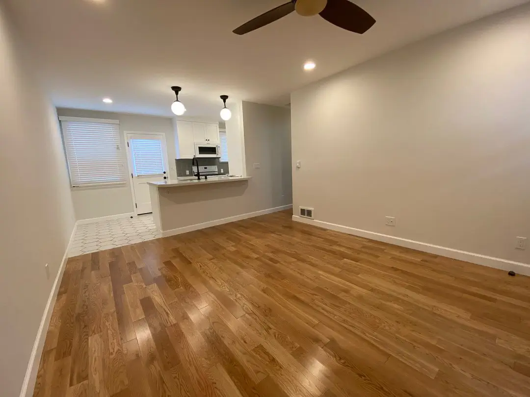 Open living area in a renovated Cabrillo Bungalows unit with oak floors and ceiling fan