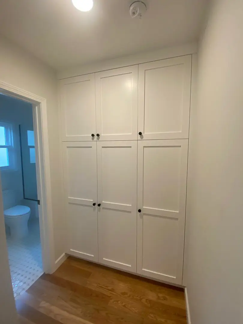 Built-in hallway storage cabinets beside a renovated bathroom at Cabrillo Bungalows