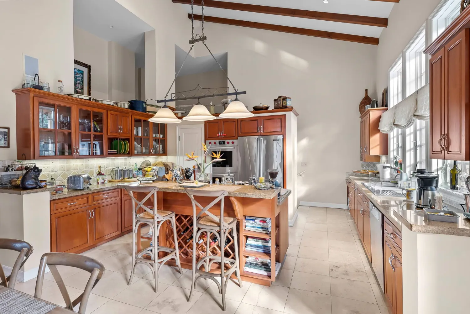 Custom kitchen with cherry cabinetry, granite island, and vaulted beamed ceiling