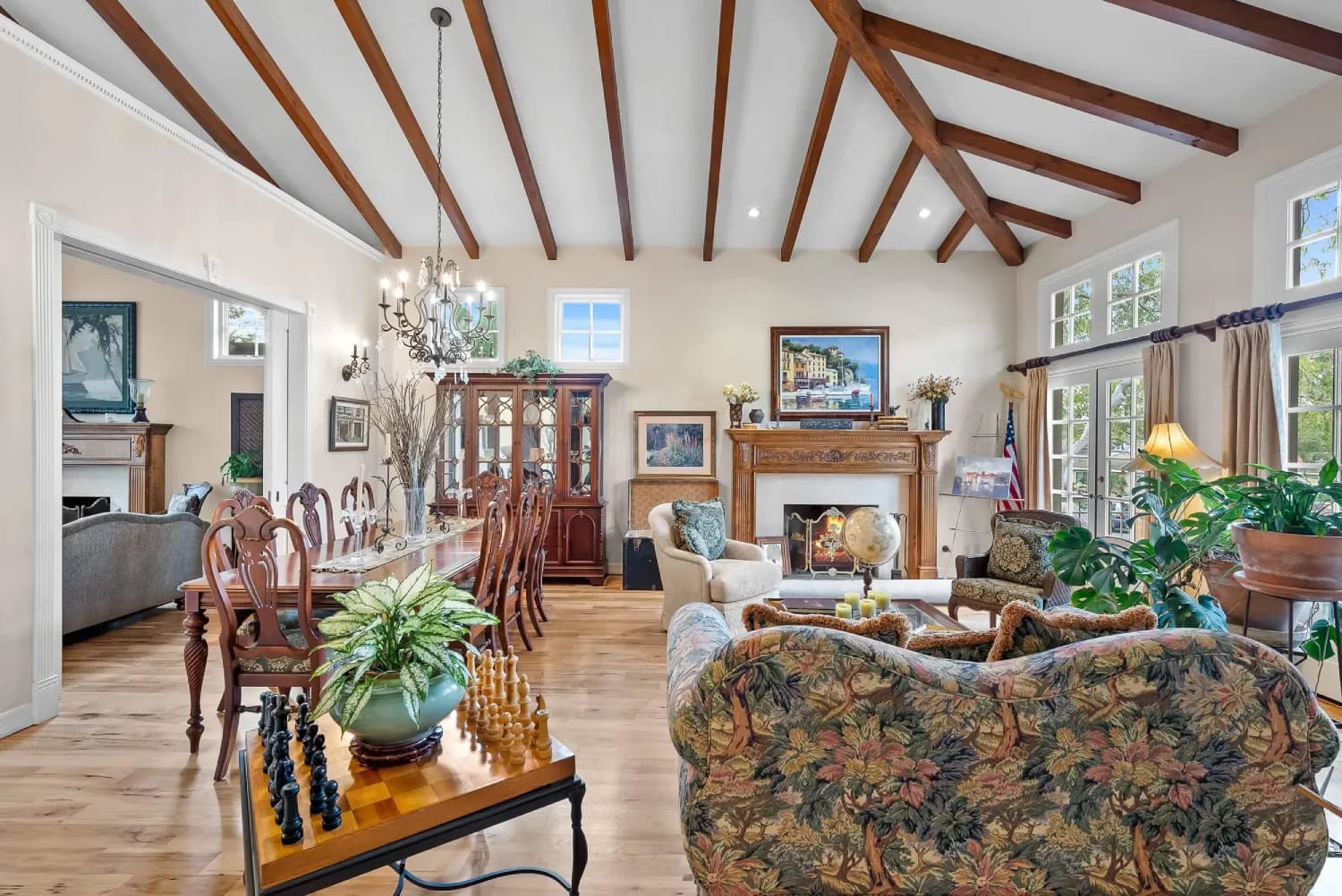 Open great room joining dining and living areas under a dramatic beamed cathedral ceiling