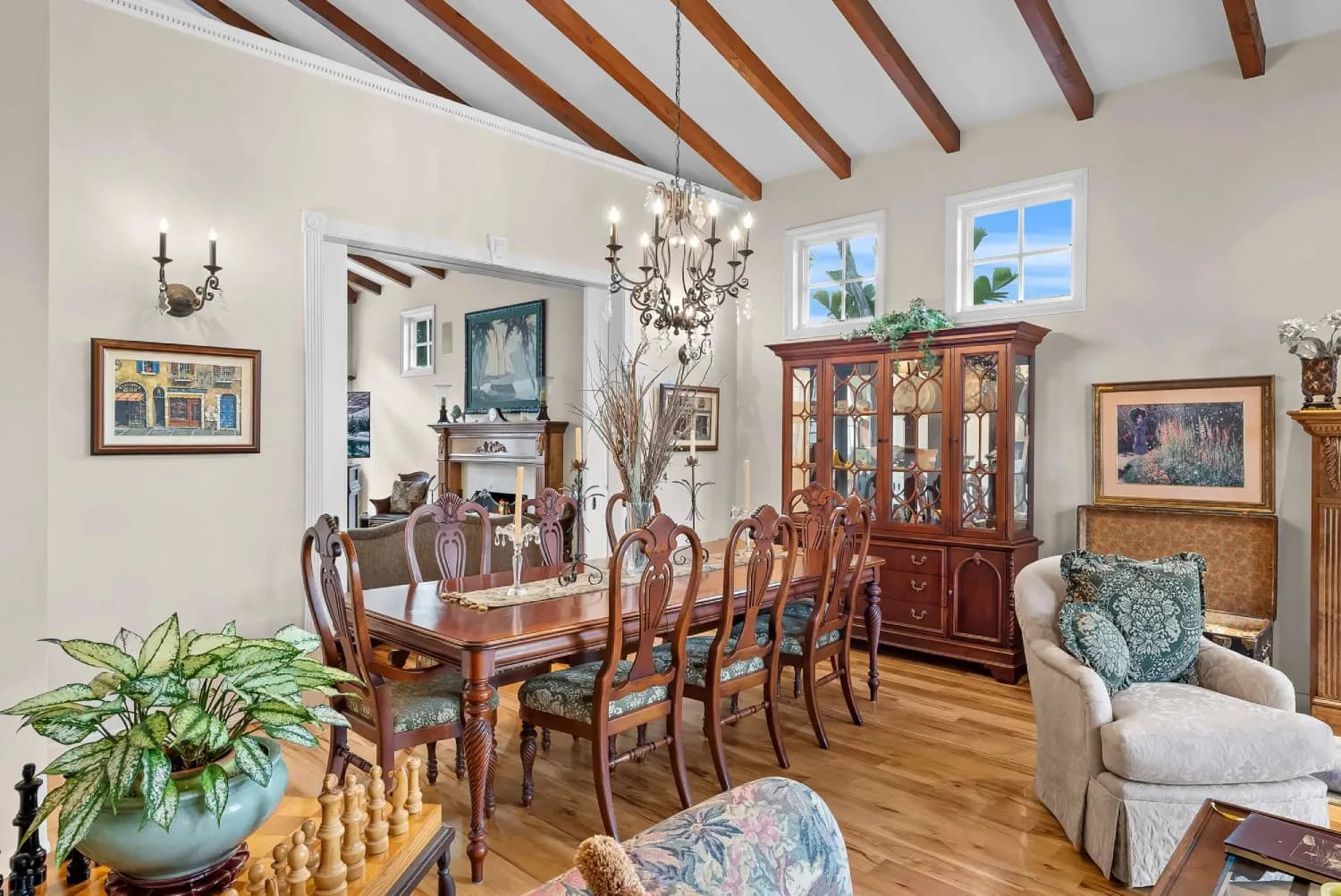 Formal dining room with exposed beams, chandelier, and built-in china hutch