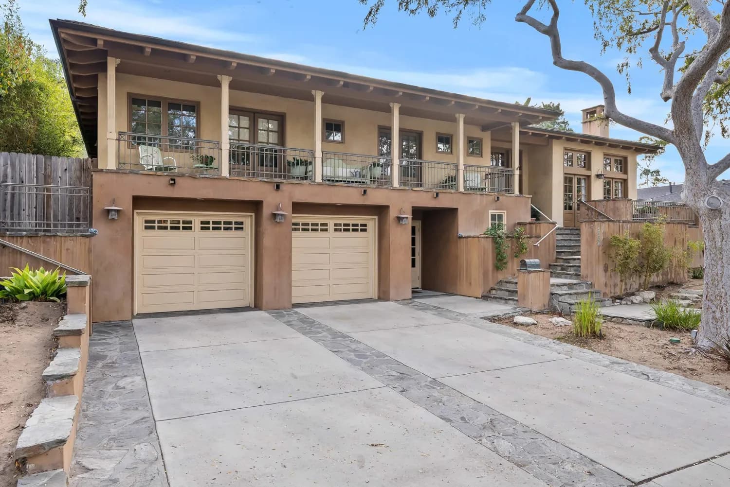Street view of the two-story custom home with covered balcony and driveway
