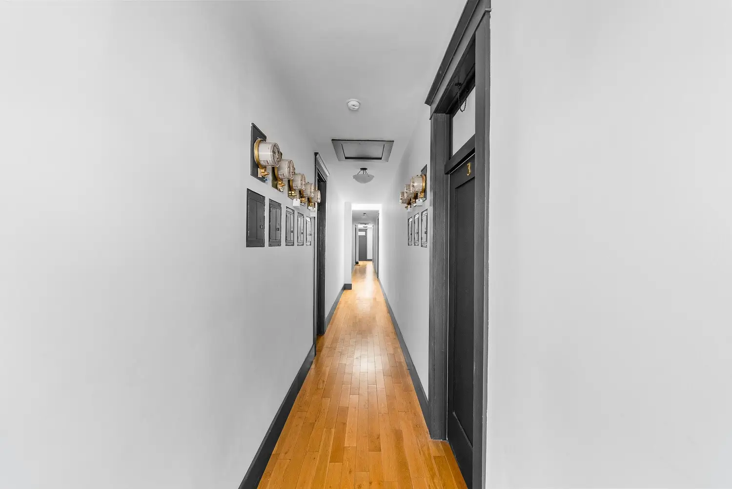 Interior stairway with oak treads, dark risers, and skylight in the Marcelina Lofts building