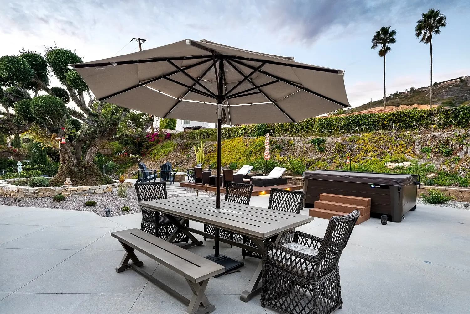 Large cantilever umbrella shading an outdoor dining table on a paver patio