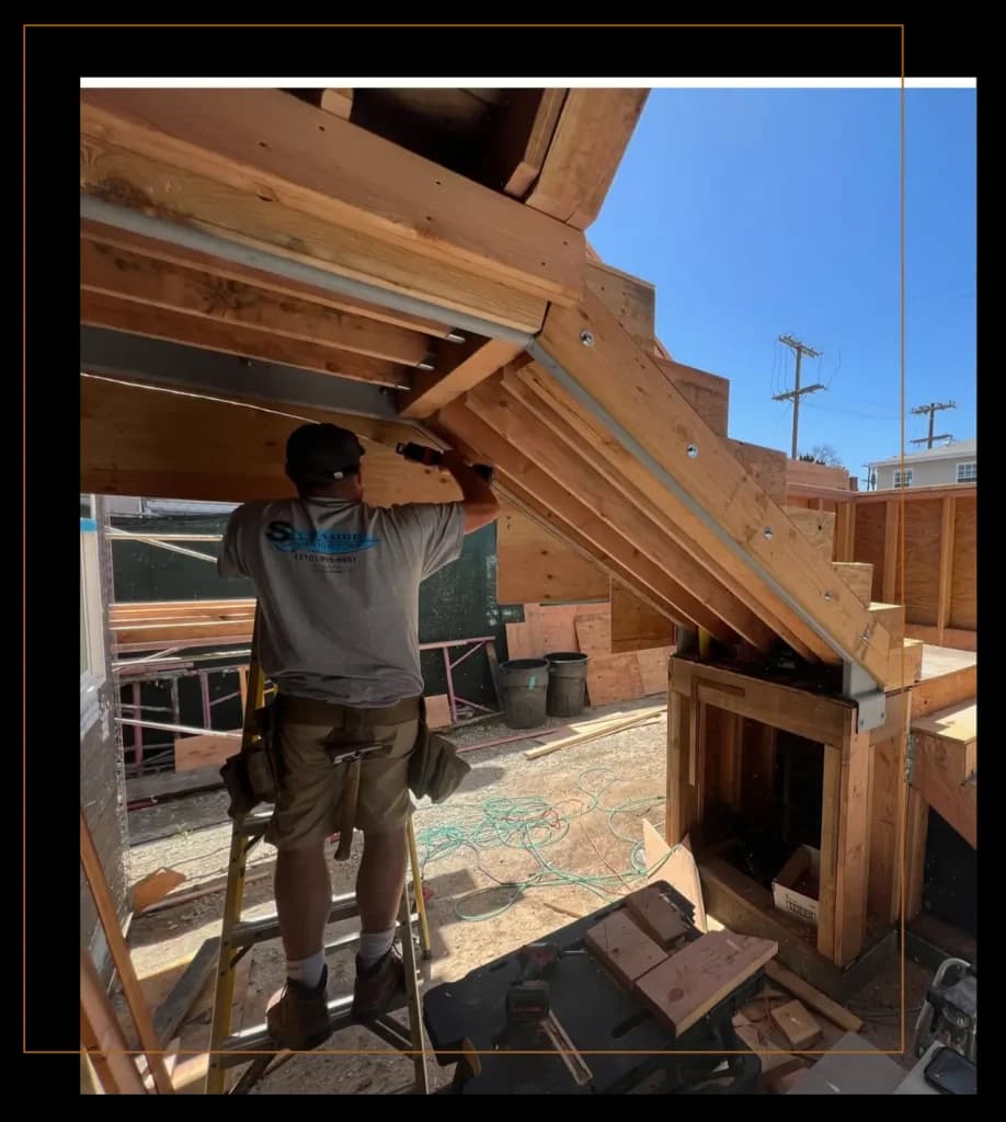 Carpenter framing a sloped roof on a wood-framed South Bay home build