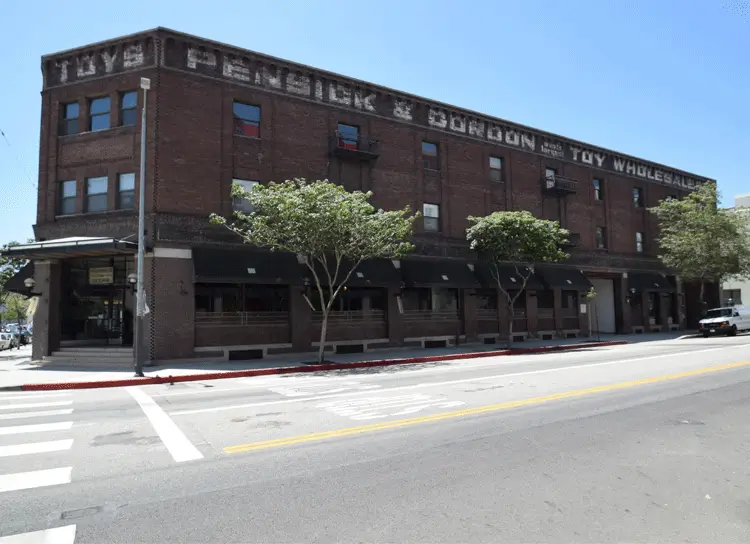 Side facade of the brick Toy Lofts warehouse showing painted Pensick and Gordon Toy Wholesale signage