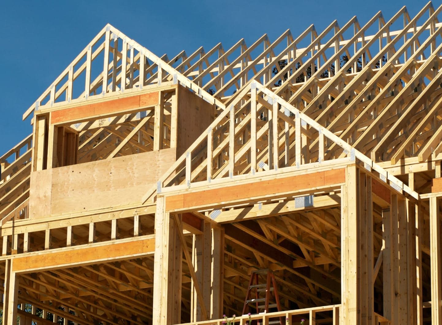 Wood-framed commercial building under construction against a blue sky — DECOMA Industries