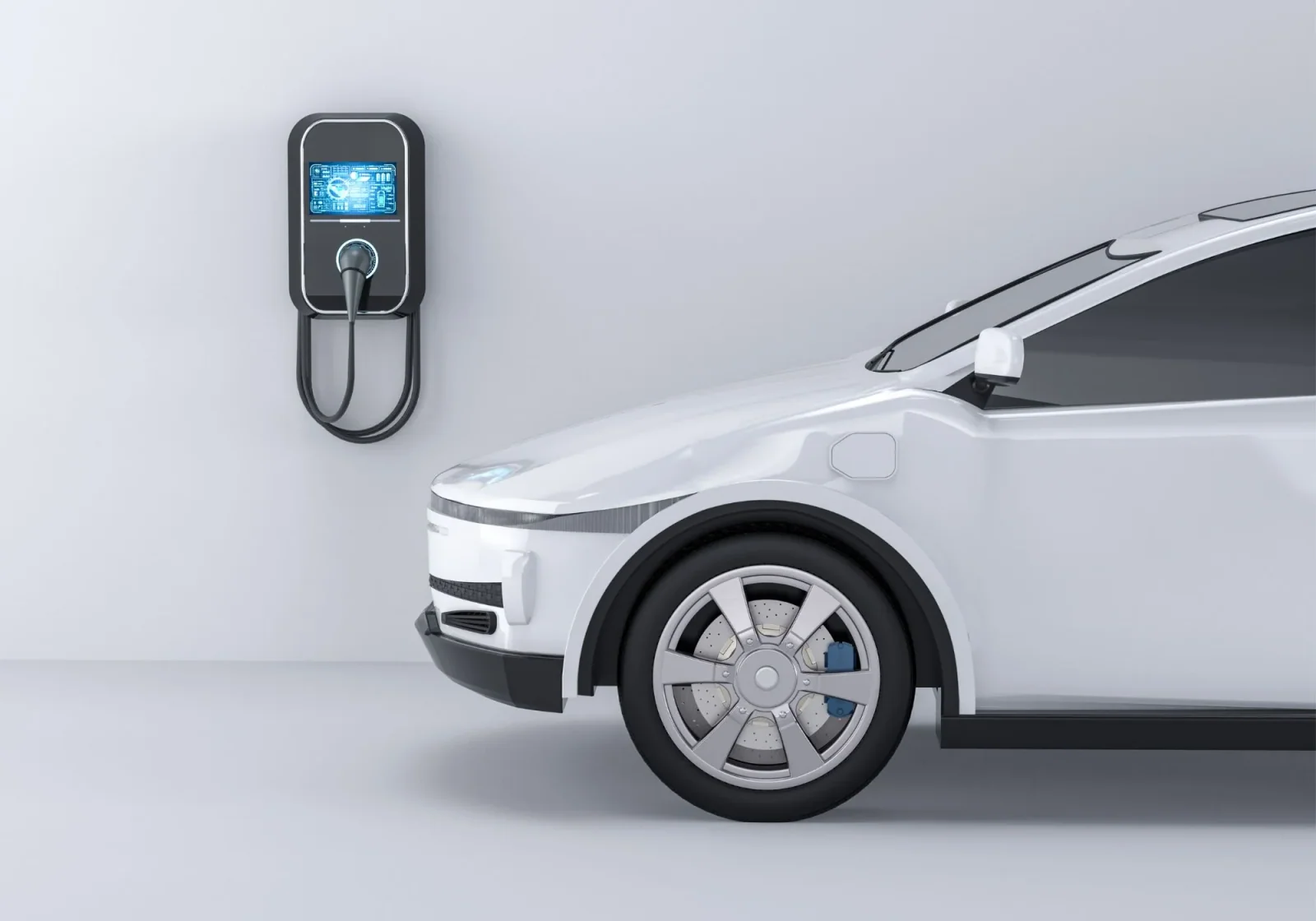 White electric car parked beside a wall-mounted EV charging station