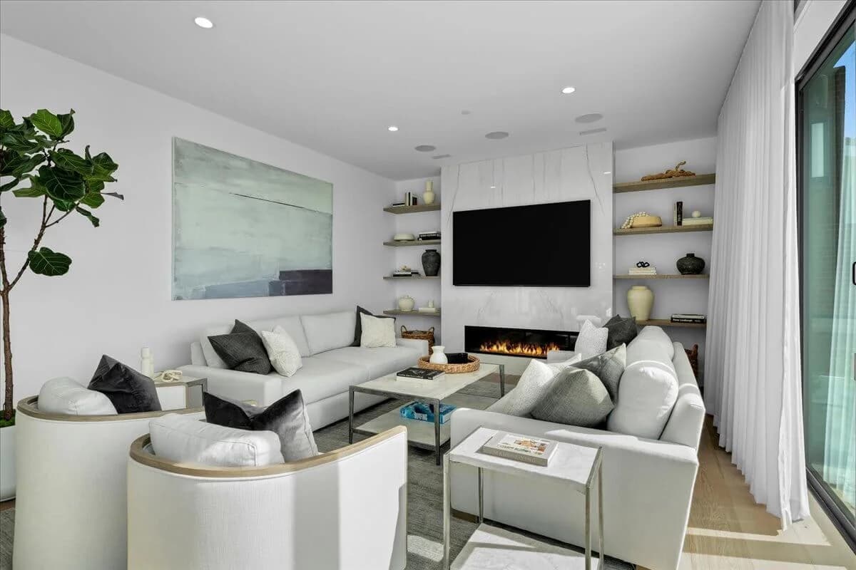Living room with linear gas fireplace, mounted TV, and built-in floating shelves
