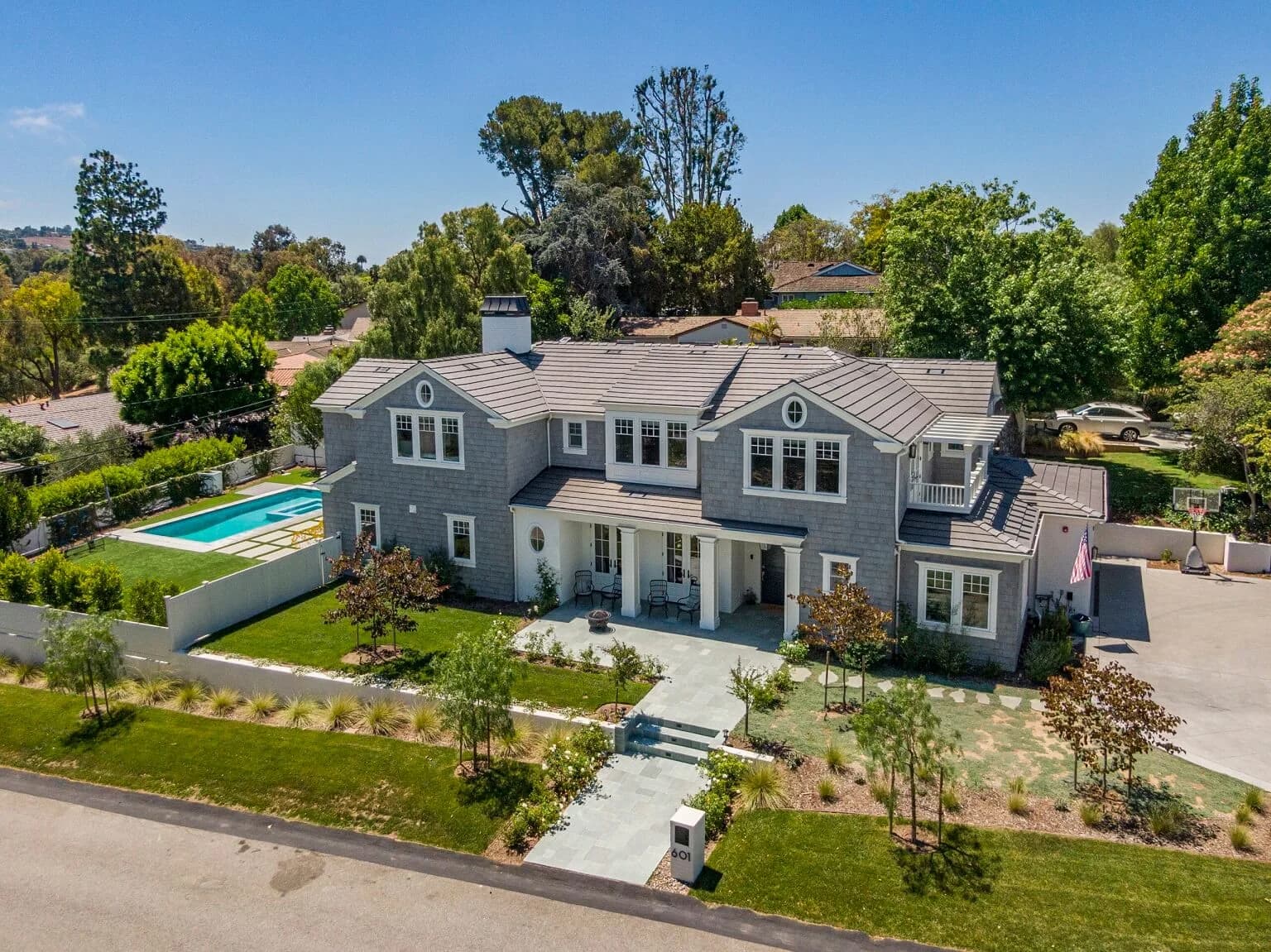 Aerial view of the finished home with pool, driveway, and landscaped yard by DECOMA Industries