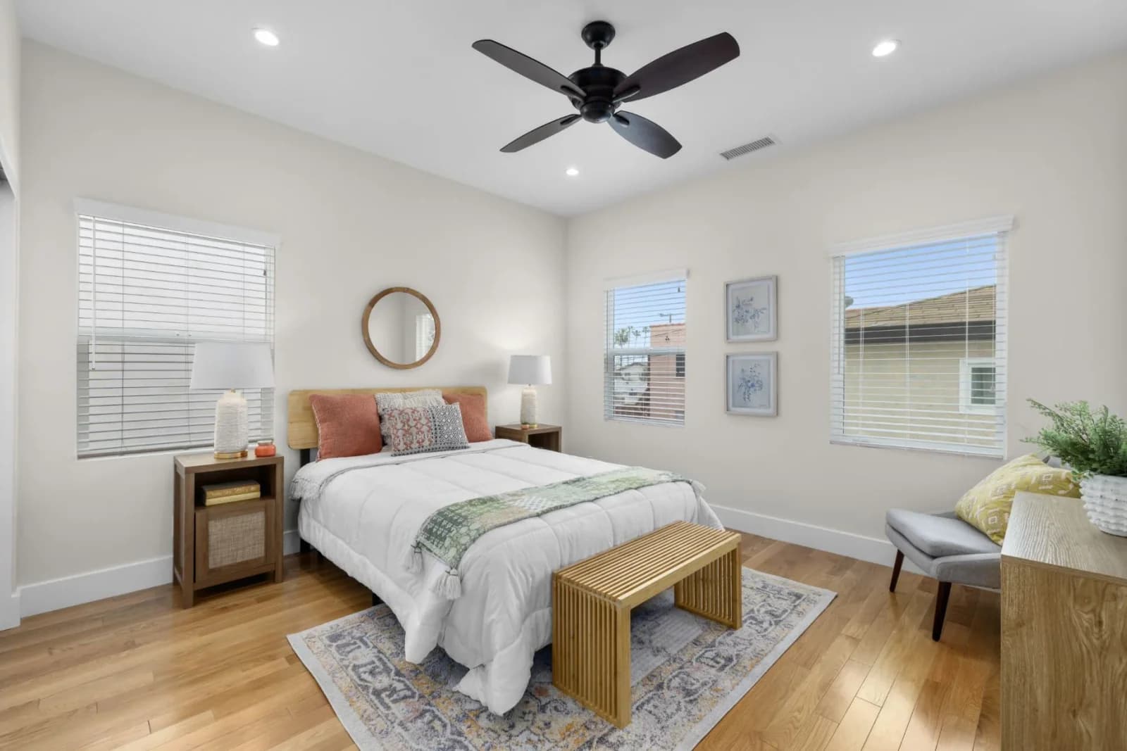 Bright staged bedroom with new hardwood floors, recessed lighting, and a ceiling fan