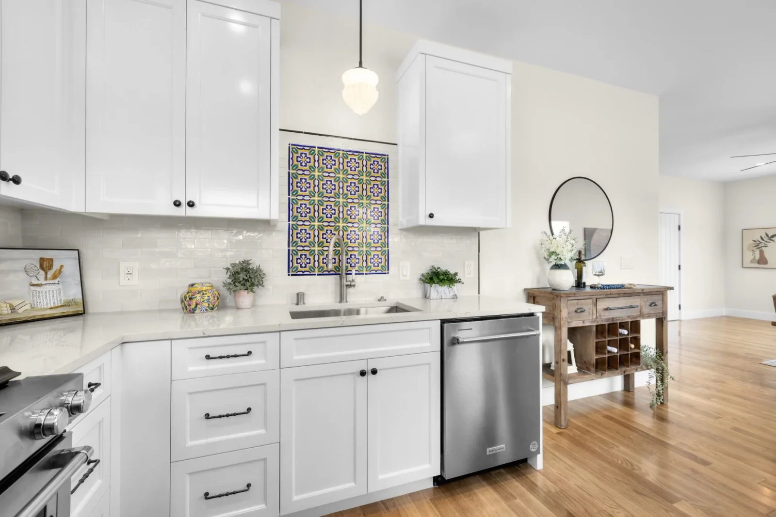 Designer kitchen with white shaker cabinets, quartz counters, and a Spanish accent-tile backsplash