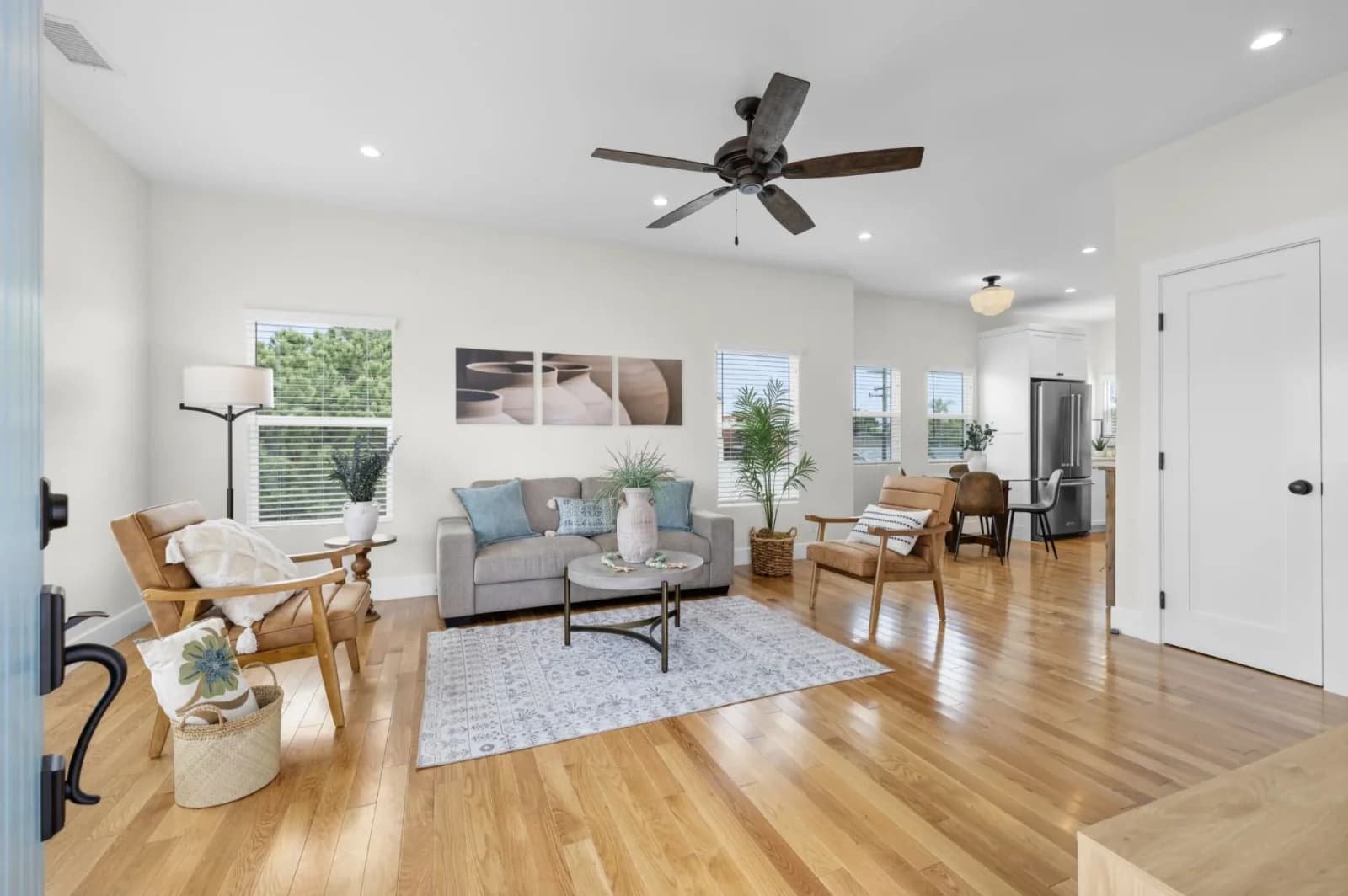 Spacious open living and dining space with hardwood floors opening toward the kitchen
