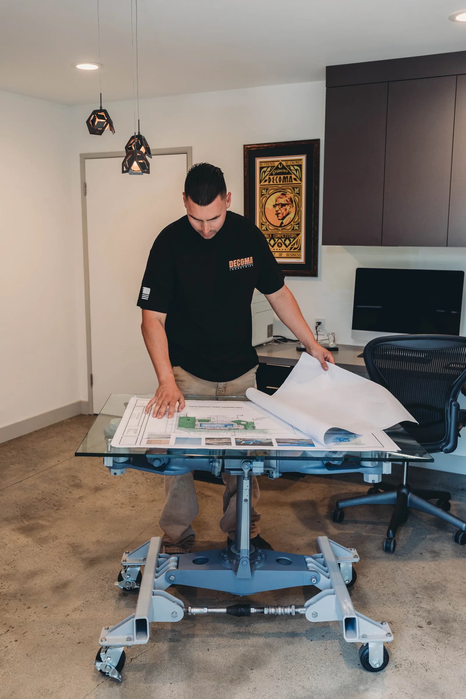 DECOMA Industries team member reviewing construction and pool design plans at the Harbor City office