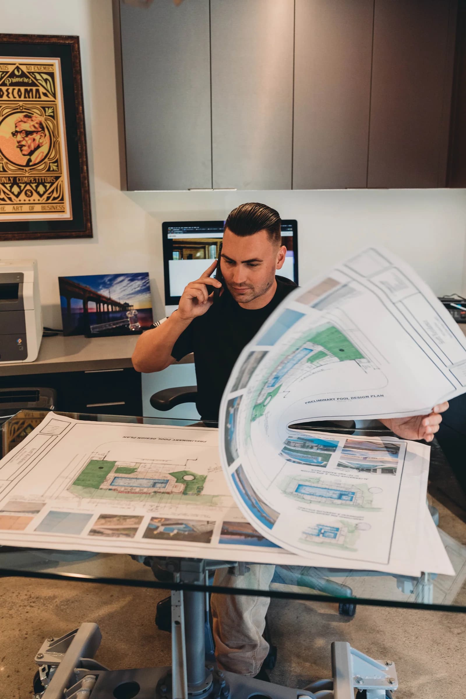 DECOMA Industries project manager reviewing preliminary pool design plans during a client consultation