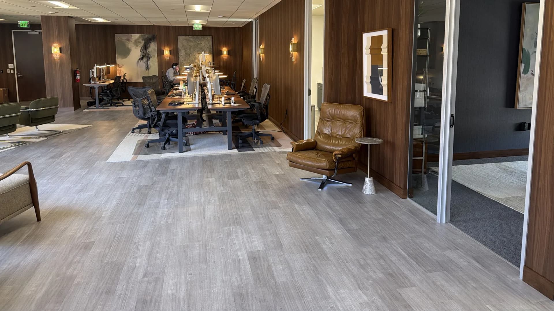 Long open workspace with walnut panels and sconces