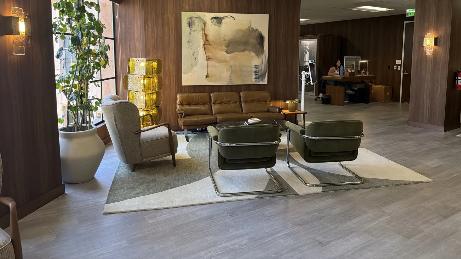 Reception lounge with sofa, armchairs, and abstract art