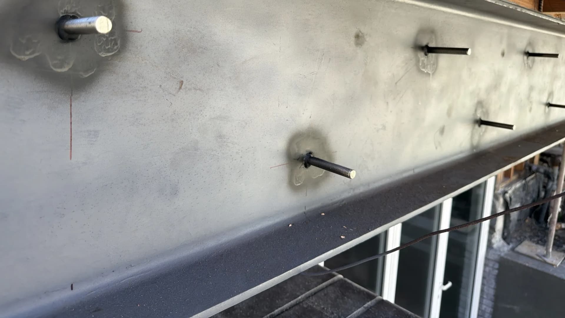 Close view of welded threaded studs along the flange of a new steel beam