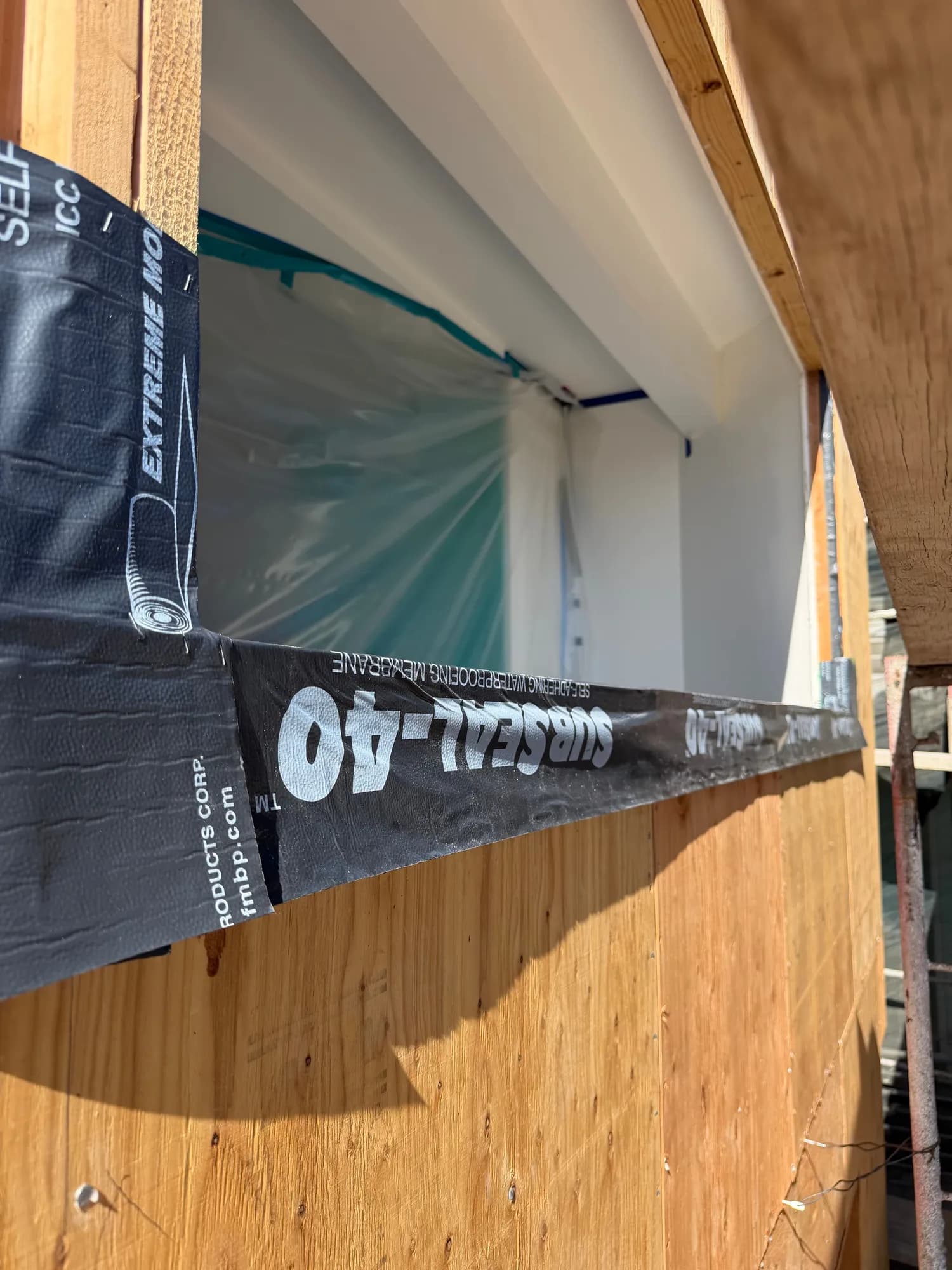 Self-adhered waterproofing membrane lapped over a window head on new sheathing
