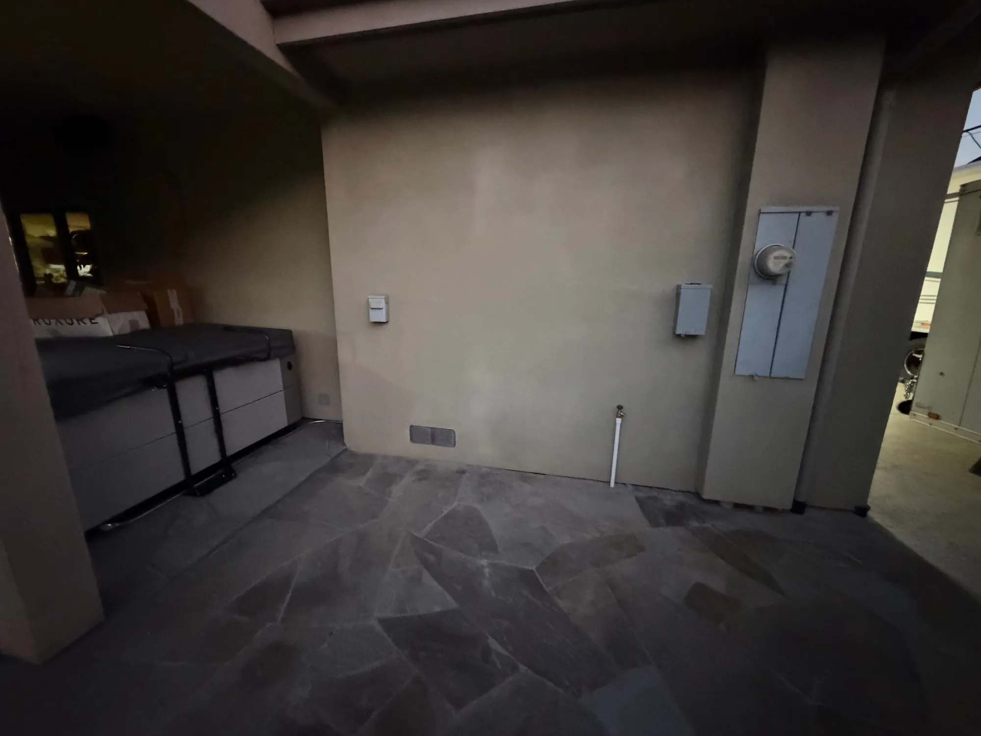 Covered flagstone patio with the hot tub in place and a new spa disconnect on the wall