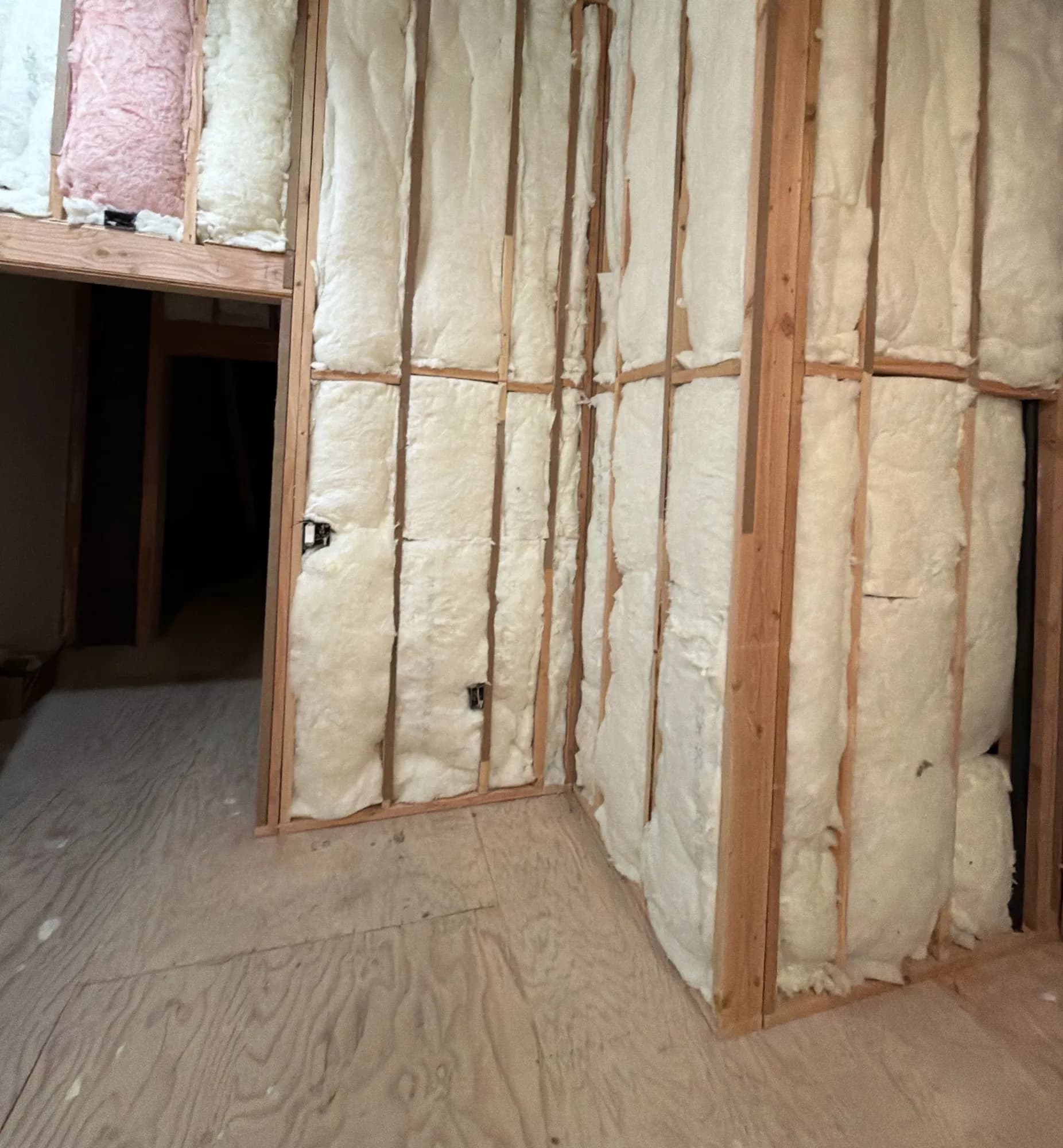 Fiberglass batt insulation in framed walls around a doorway