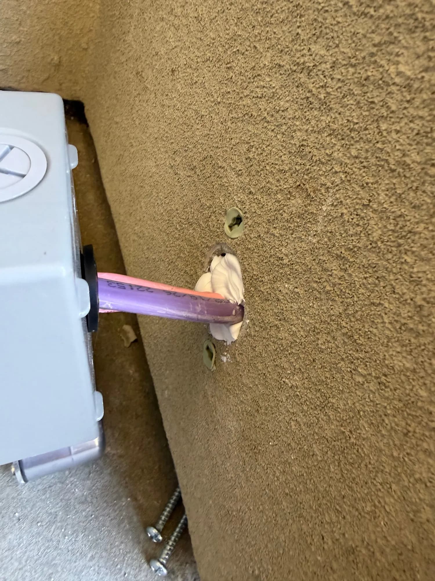 Sealed cable penetration through a stucco wall into an outdoor electrical box